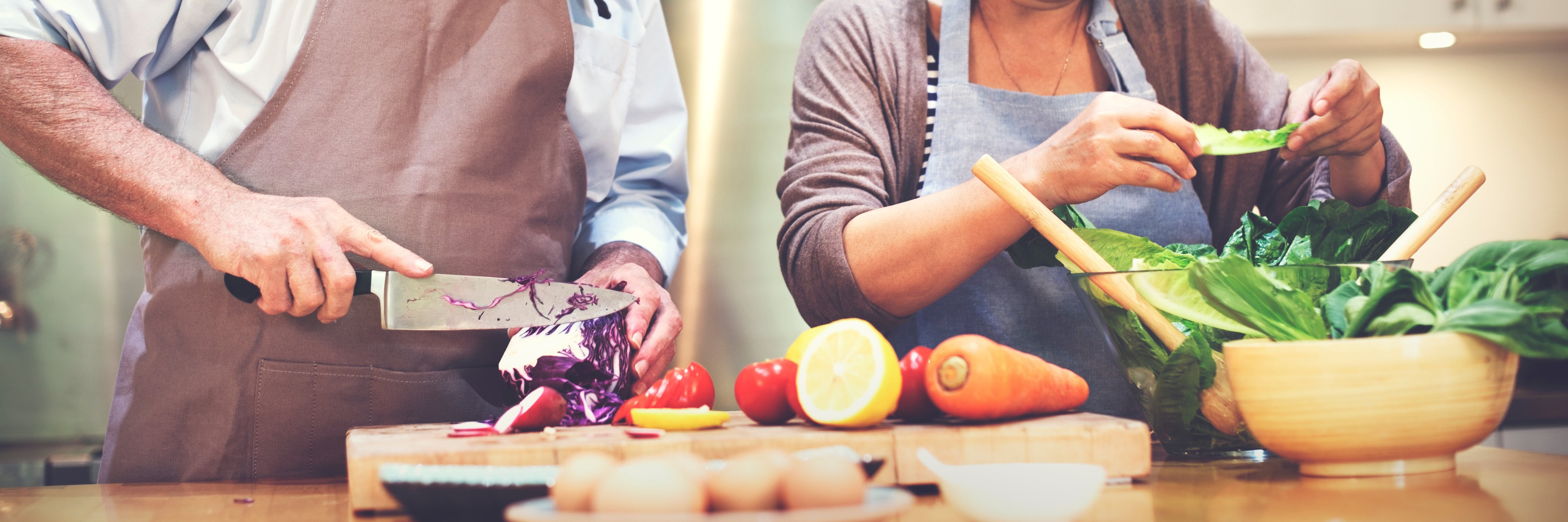 Healthy foods being prepared by a couple in the kitchen