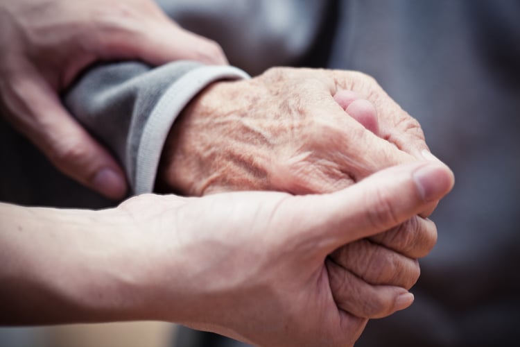 Two seniors holding hands and talking about the differences between Dementia, Alzheimer’s, Parkinson’s, and Mild Cognitive Impairment 