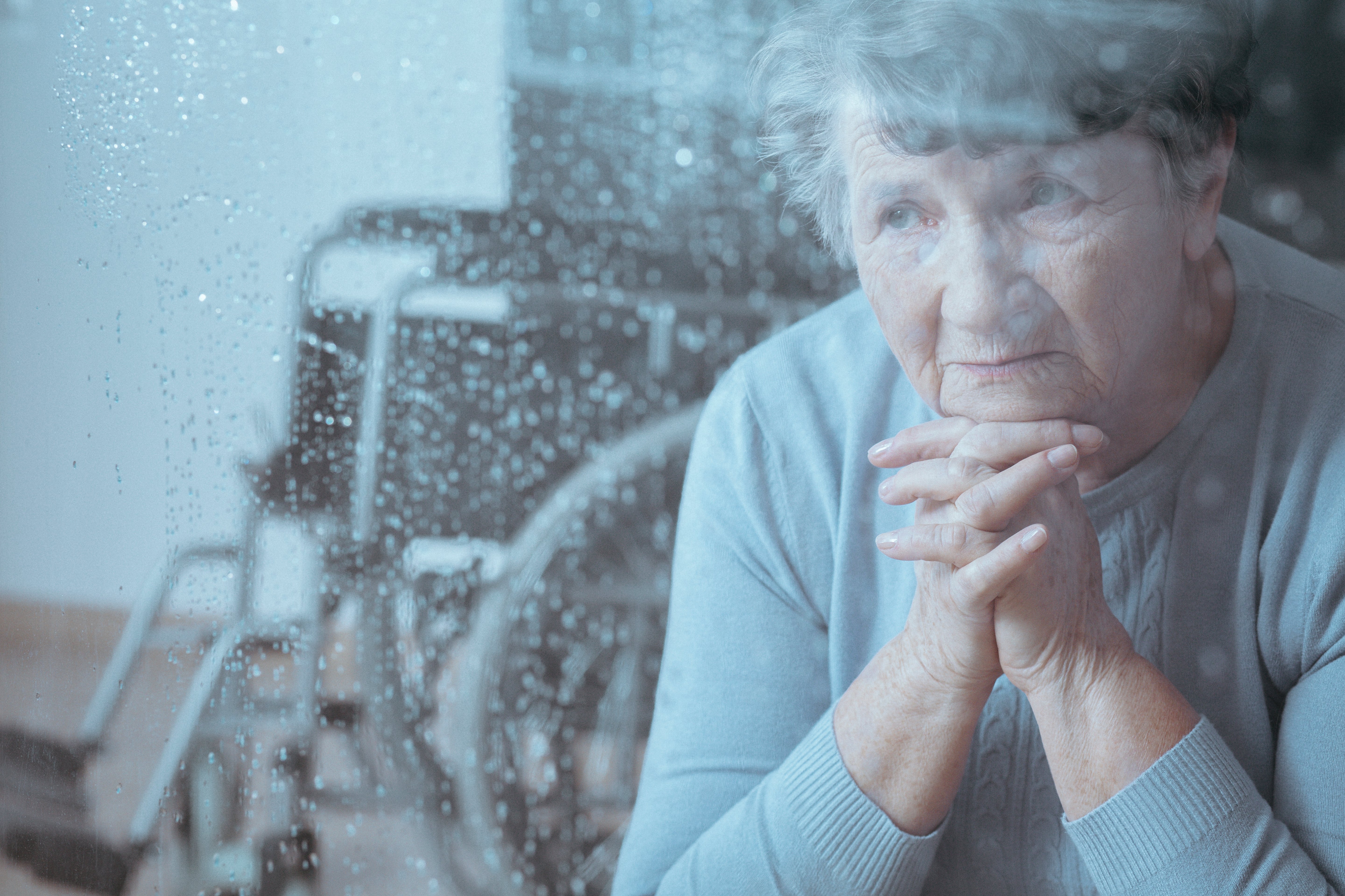 Resident sitting looking out a rainy window