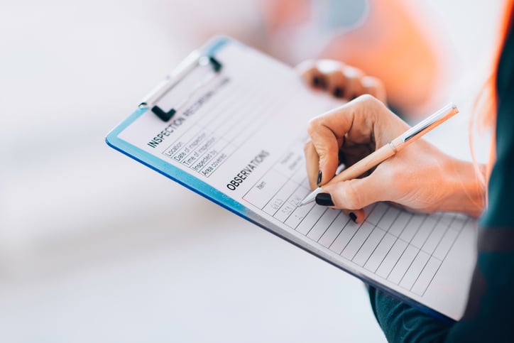 Lady taking observation notes on a clipboard 