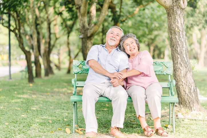 older couple sitting on a bench together