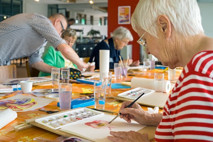 women painting a picture with others