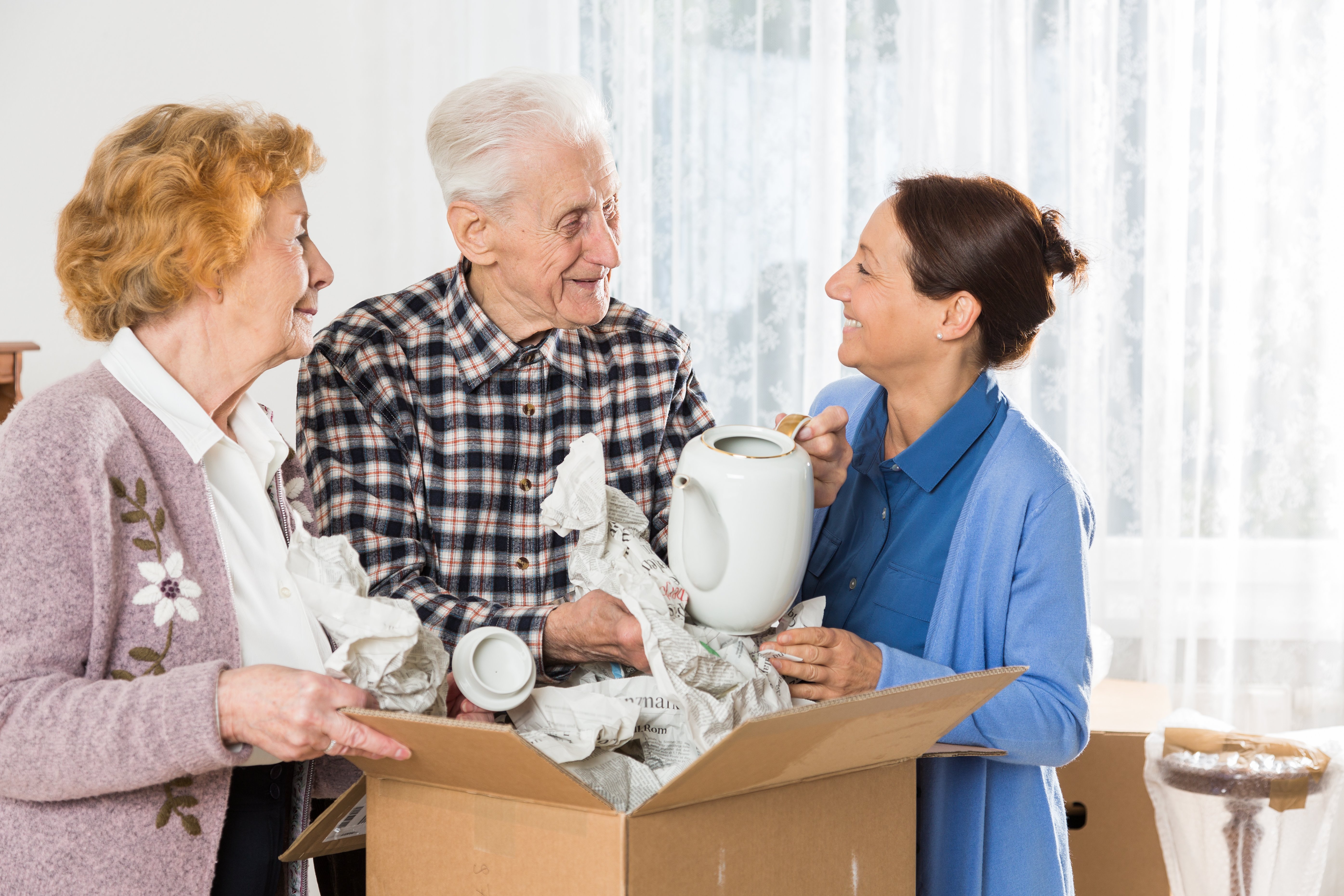 Elderly couple going through their belongings with their daughter