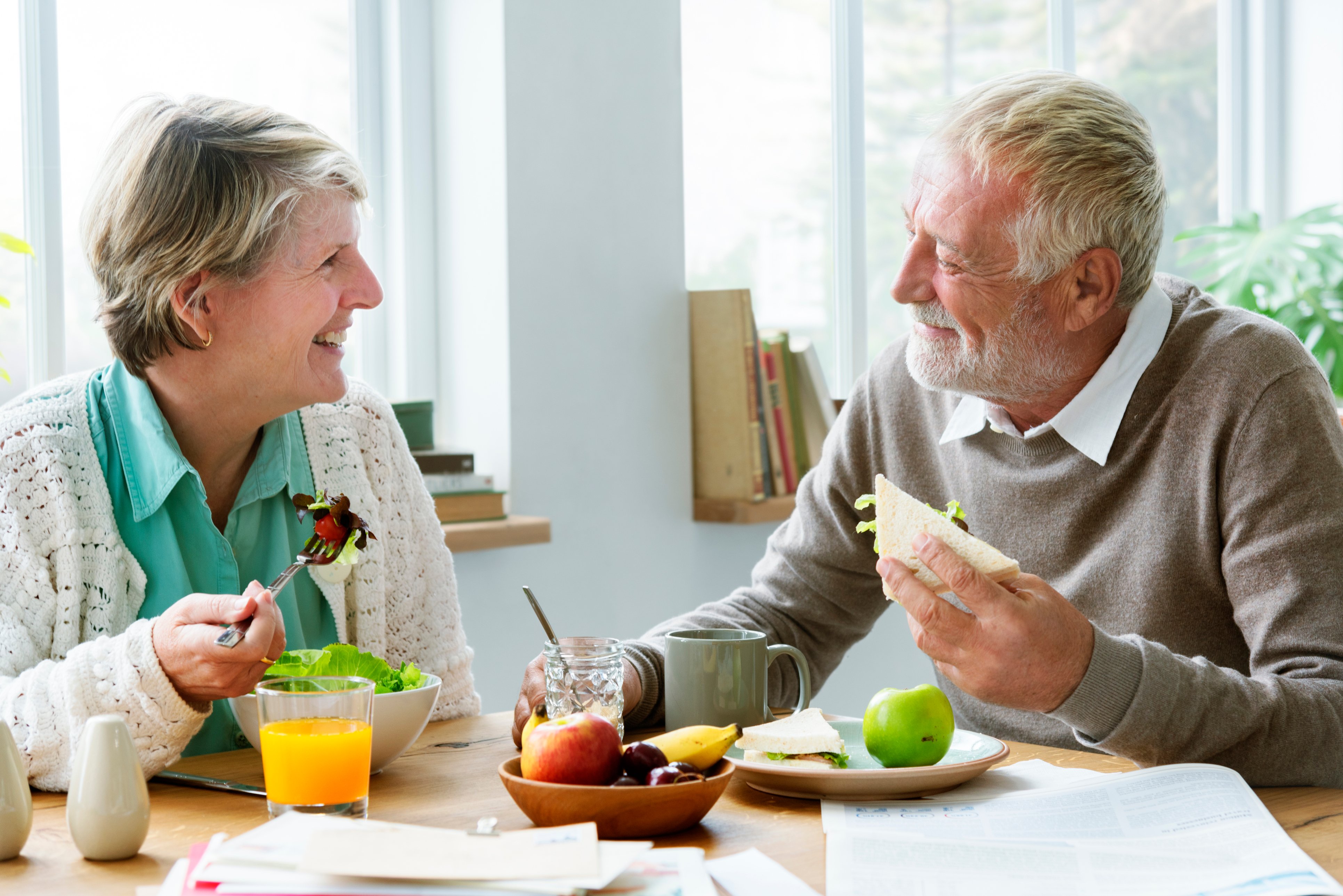 Husband and wife enjoying a healthy lunch together and exchanging smiles to one another