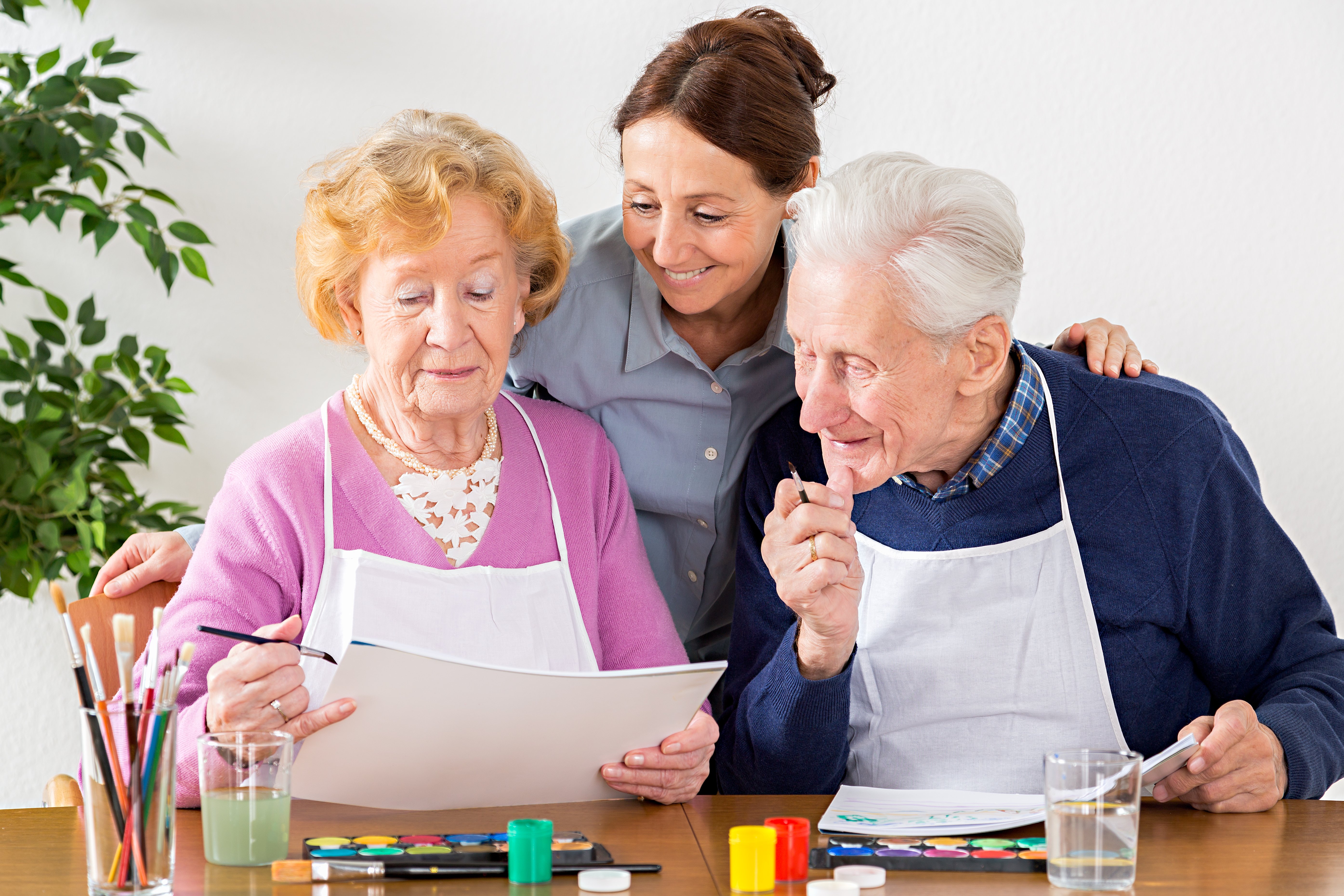 A senior couple participating in a painting activity. 