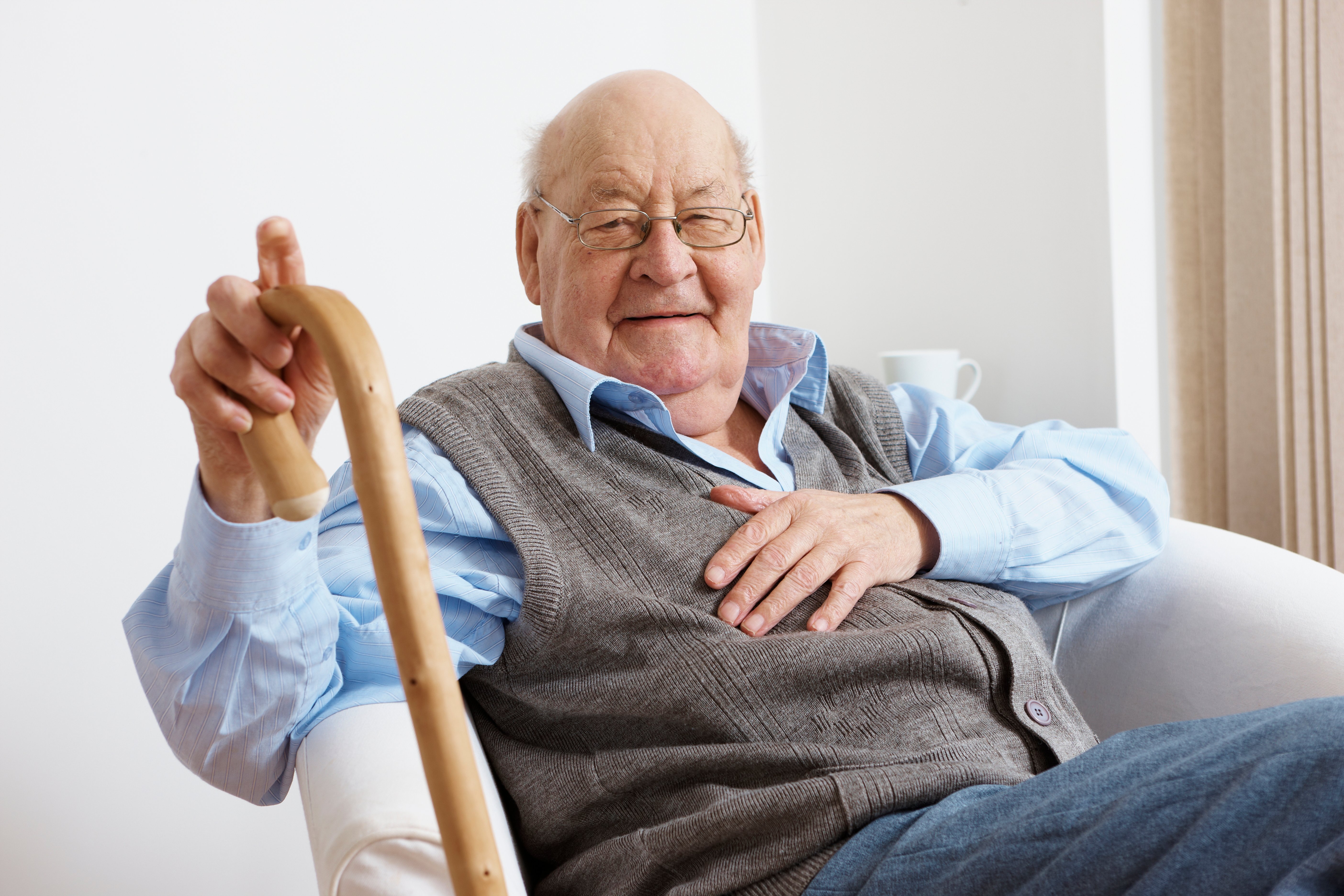 Happy elderly man sitting in a chair