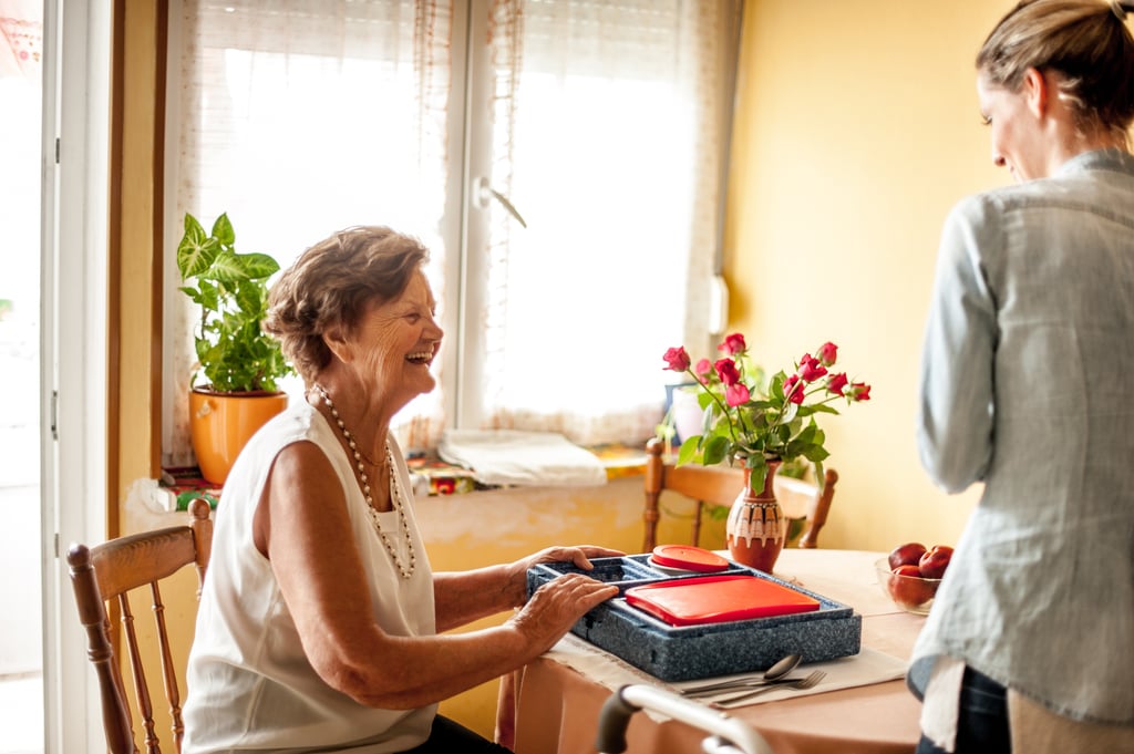 Adult child who is a family caregiver speaking with senior parent discussing the benefits of a short term respite stay in assisted living