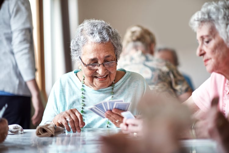 Group of seniors playing cards living a life of purpose in highgate at temecula assisted living