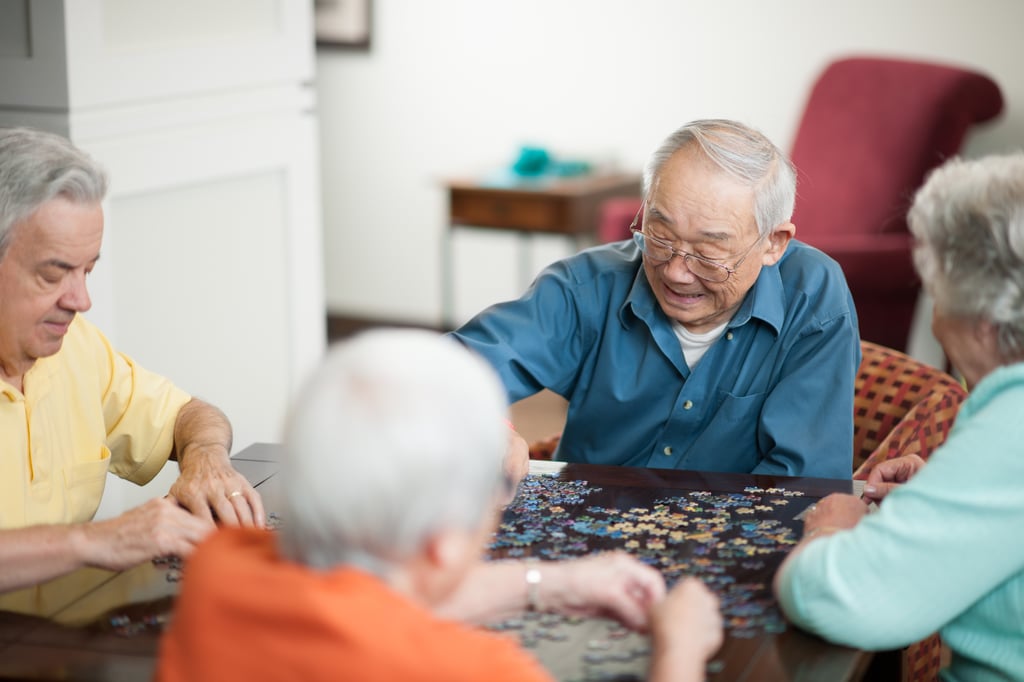 Group of four seniors living with memory loss slowing the progression by taking part in creative group activities.