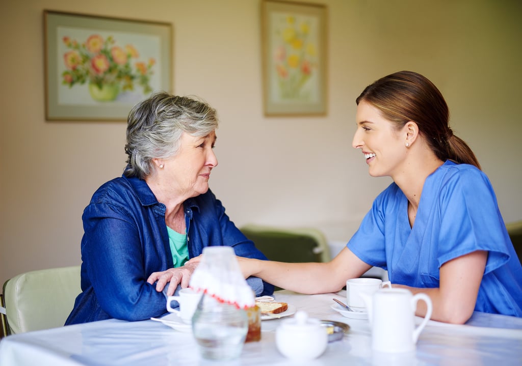 Caretaker speaking with senior mother over a healthy meal discussing why her appetite may have changed