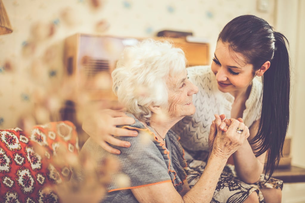 Senior woman holding hands with her caregiver child asking about what a respite stay is.