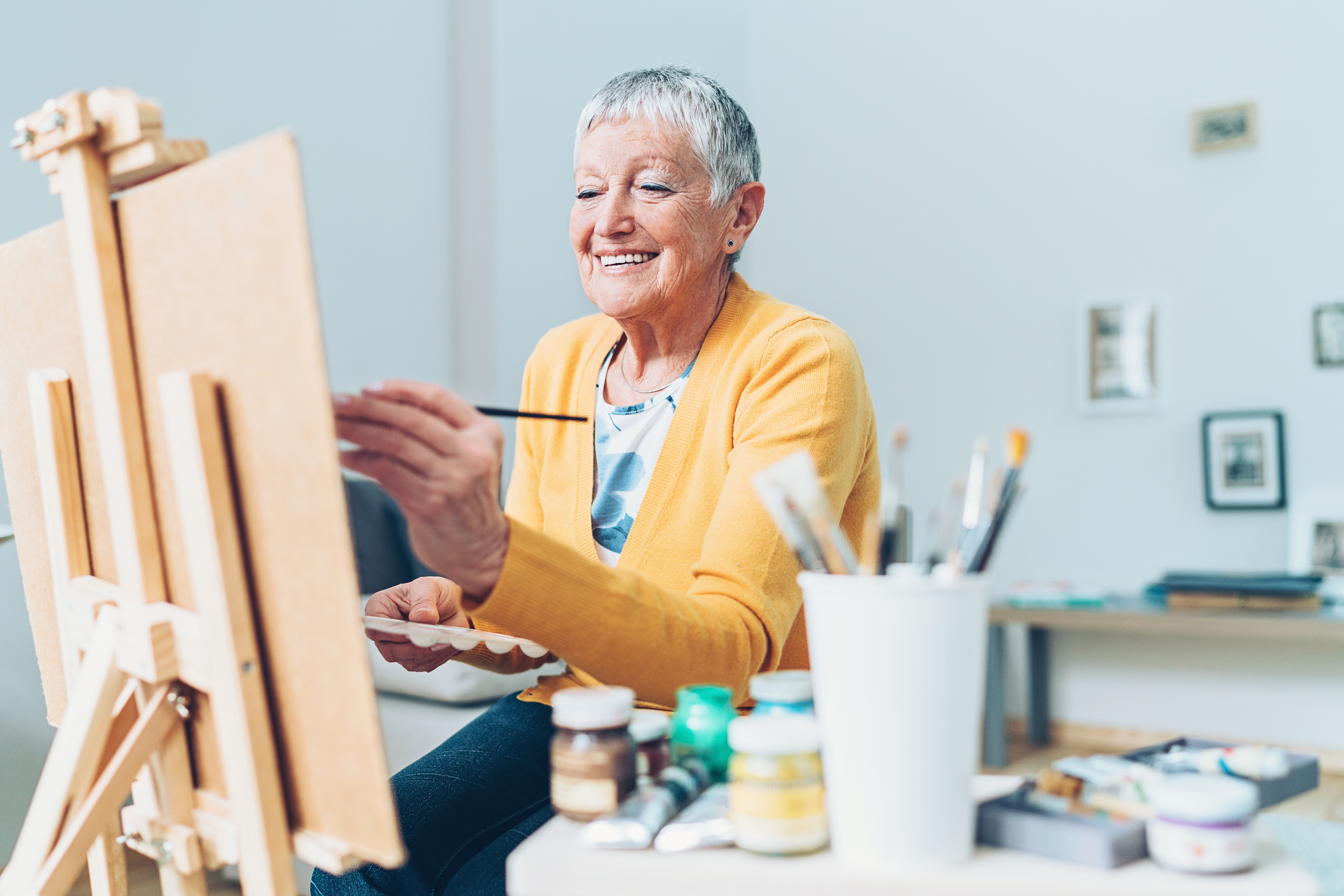 Senior with alzheimer's keeping active and engaged by painting in assisted living