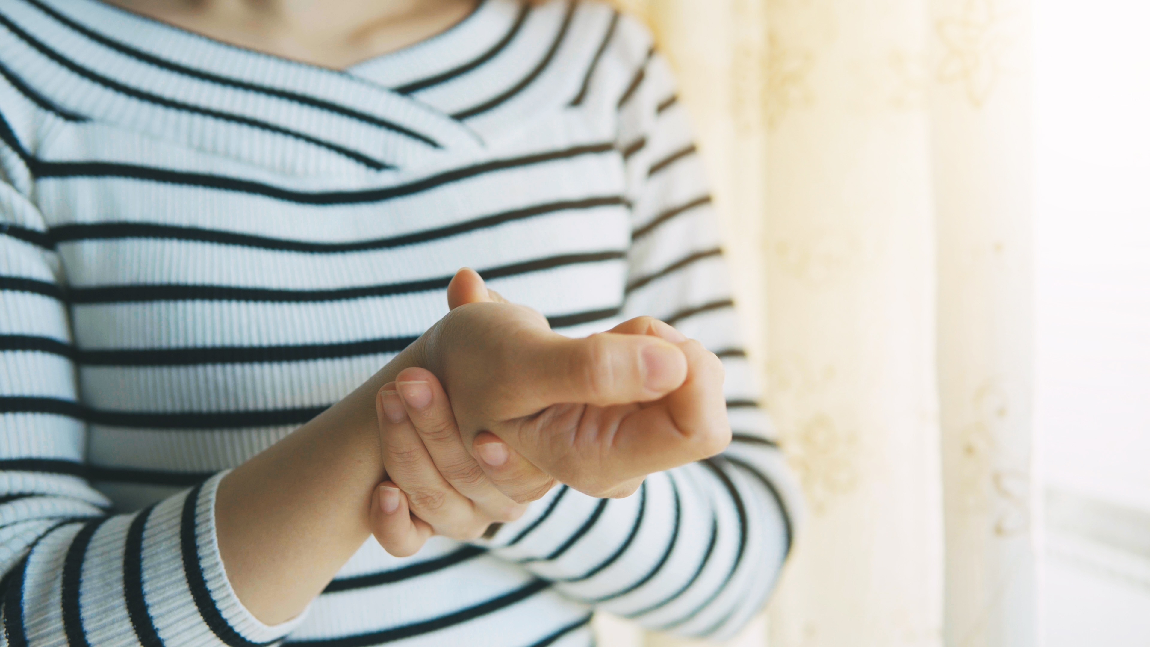 Senior woman massaging wrist to manage arthritis pain