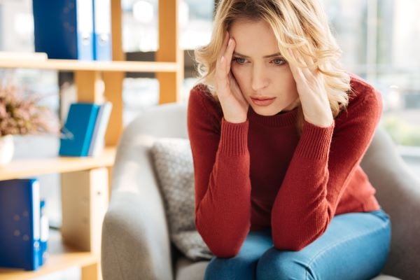 women sitting on the couch deep in thought 