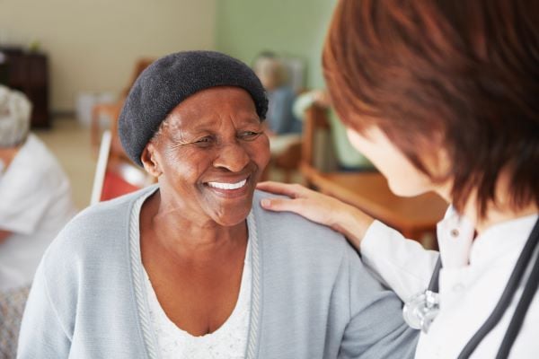 Assisted living resident smiling at a healthcare professional