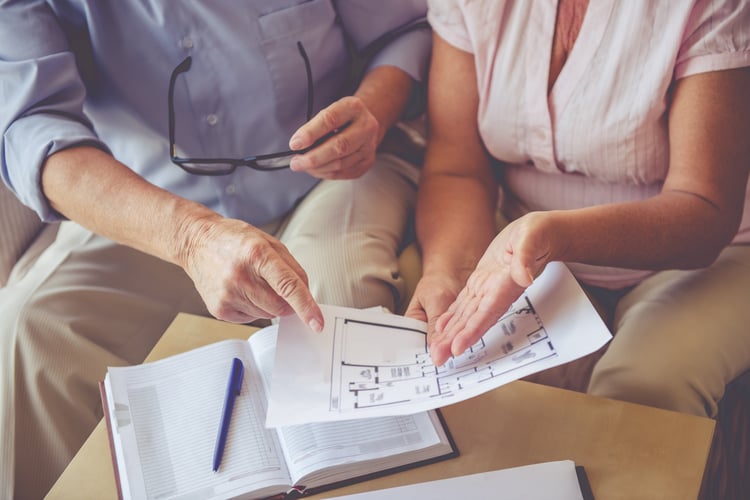 Seniors looking at floor plans and deciding which housing is best for their senior living needs