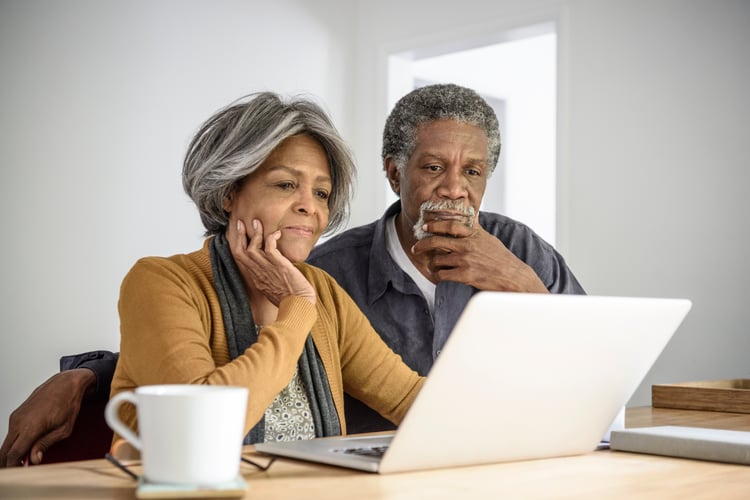 Senior couple looking at computer researching if assisted living costs are affordable