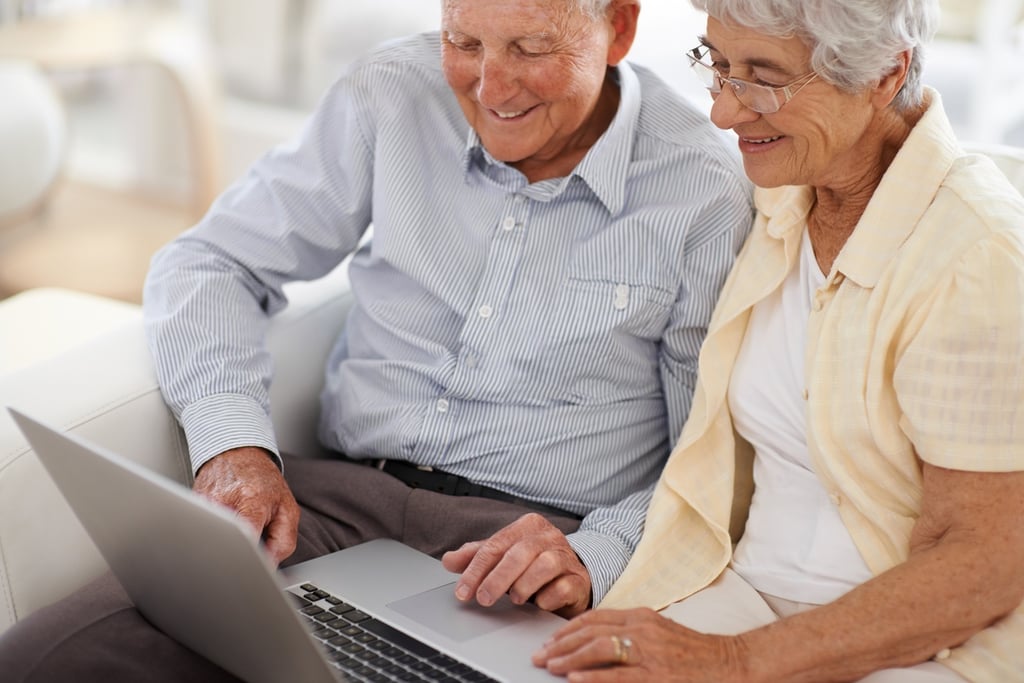 elderly couple on computer researching assisted living costs questions 