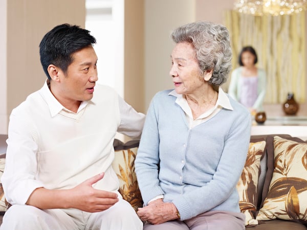 Son & mother sitting on a couch having a conversation