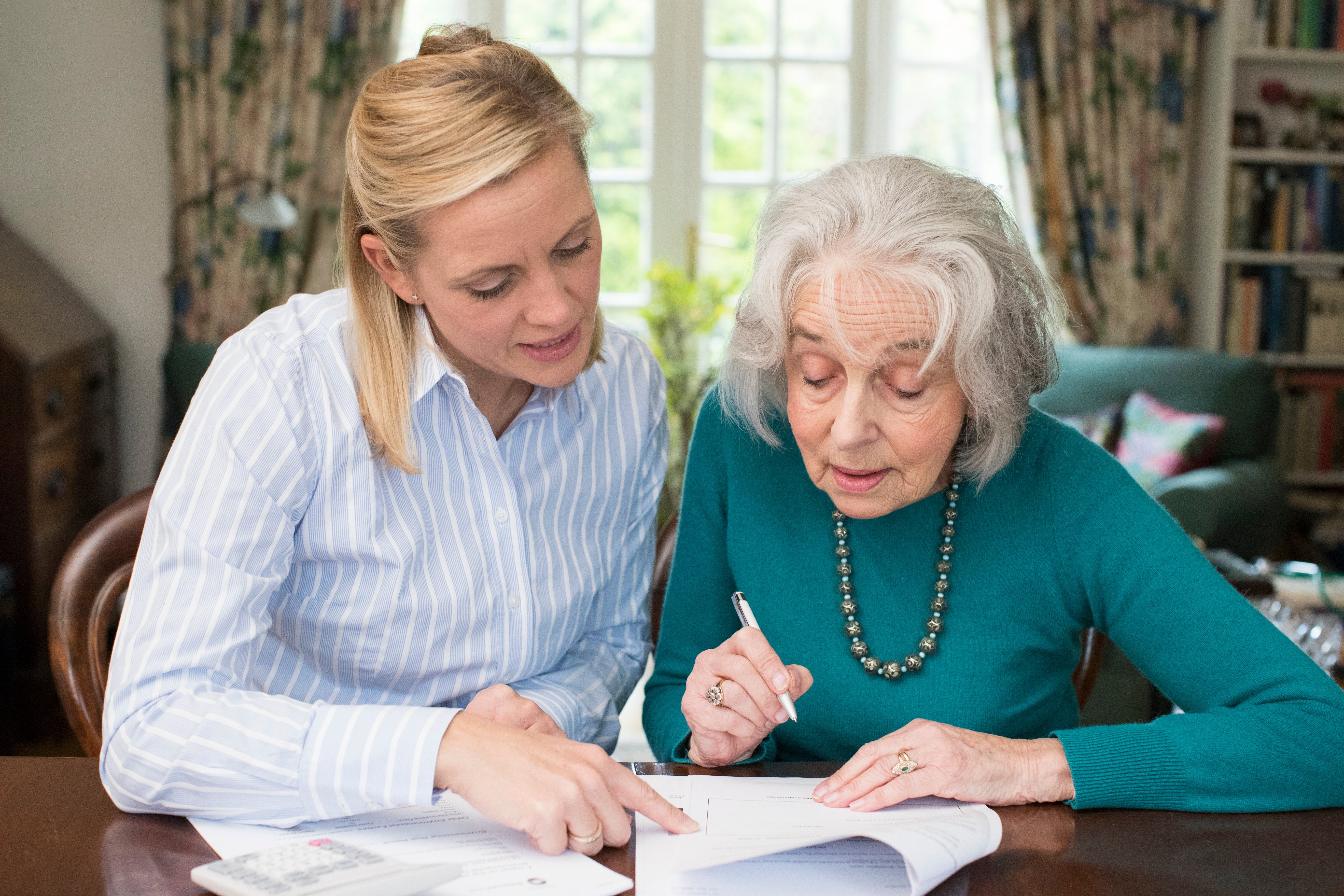 Mother and daughter going over paper documents for Power of Attorney