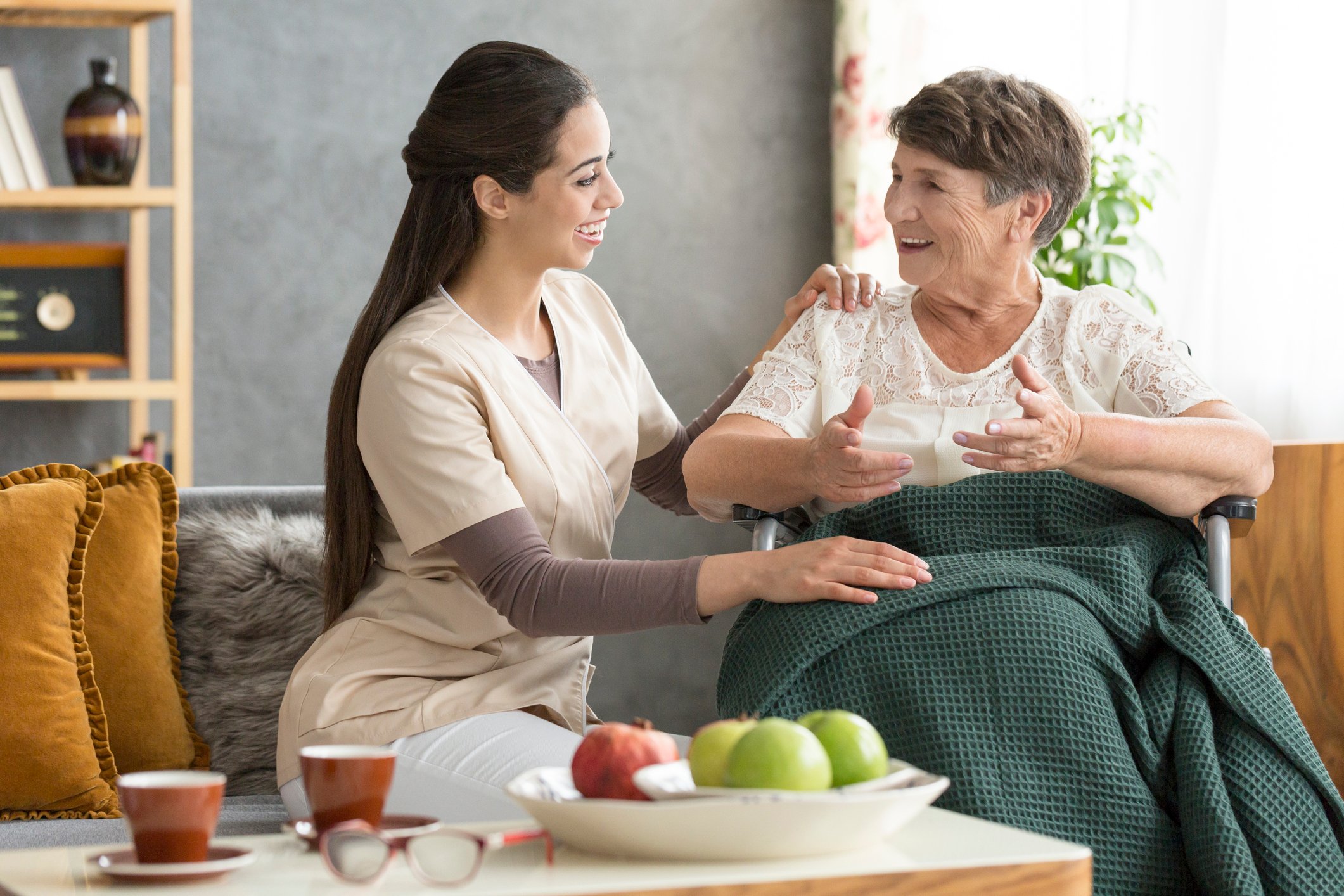 Healthcare professional having a conversation with a resident and sharing smiles with one another